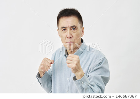 A man strikes a fighting pose against a white background. A man strikes a fighting pose against a white background. 140667367