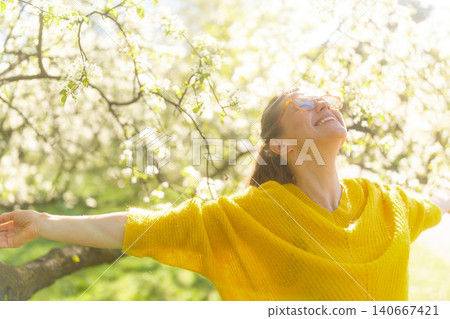 Joyful Woman Embracing Nature in a Spring Orchard Joyful Woman Embracing Nature in a Spring Orchard 140667421