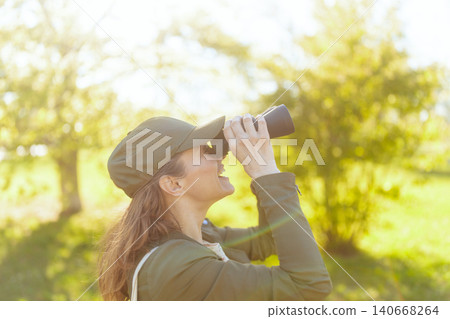 Smiling Woman Enjoying Bird Watching Adventure Smiling Woman Enjoying Bird Watching Adventure 140668264