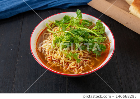 bowl of Instant Noodles Generously Topped with Fresh Coriander. Asian Style Spicy Ramen Soup, Quick Comfort Food. 140668283