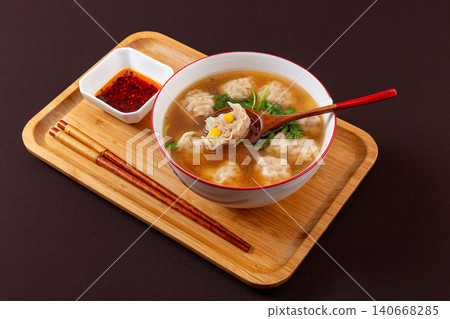 chinese Wonton Soup with Sweet Corn and Pork Stuffing. Hot Asian Dumpling Soup with Cilantro, Comfort Noodle Alternative. 140668285