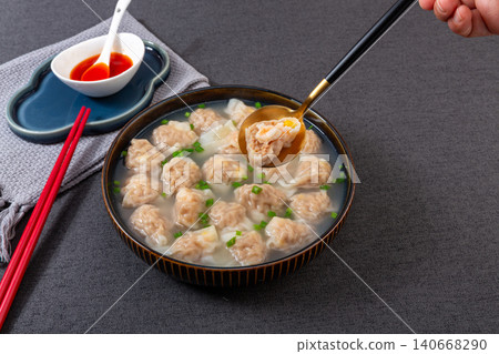 bowl of traditional Chinese pork and shrimp wontons in clear broth with chopped scallions, classic dim sum soup bowl of traditional Chinese pork and shrimp wontons in clear broth with chopped scallions, classic dim sum soup 140668290