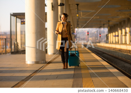 Connected Traveler Walking with Luggage at Railway Hub Connected Traveler Walking with Luggage at Railway Hub 140668430