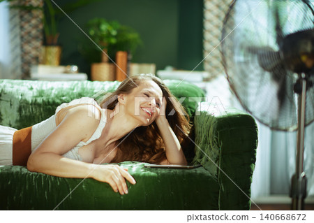 Calm Woman Resting on Sofa with Fan and Tablet Calm Woman Resting on Sofa with Fan and Tablet 140668672