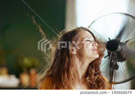 Profile of Woman Relishing Fan\'s Gentle Breeze Profile of Woman Relishing Fan\'s Gentle Breeze 140668674