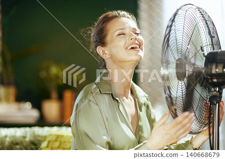 Happy Woman Embracing Fan\'s Breeze in Summer Happy Woman Embracing Fan\'s Breeze in Summer 140668679