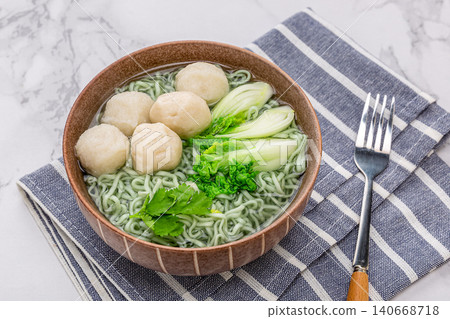 Healthy green spinach noodles with white fish balls and bok choy cabbage in a ceramic bowl Healthy green spinach noodles with white fish balls and bok choy cabbage in a ceramic bowl 140668718
