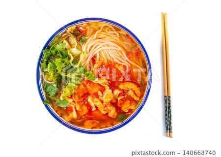 Classic Chinese tomato and egg noodle soup garnished with fresh green vegetables in a blue ceramic bowl Classic Chinese tomato and egg noodle soup garnished with fresh green vegetables in a blue ceramic bowl 140668740