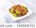 Savory stir-fried noodles with tender sliced beef and crisp green celery on a white plate 140668741
