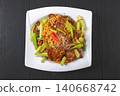 Savory stir-fried noodles with tender sliced beef and crisp green celery on a white plate 140668742