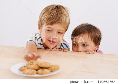 Children, boys and smile for cookies in home with stealing, peeking and childhood fun in at dining room table. Siblings, kids and happy for biscuits, snack and baked goods in kitchen of apartment Children, boys and smile for cookies in home with stealing, peeking and childhood fun in at dining room table. Siblings, kids and happy for biscuits, snack and baked goods in kitchen of apartment 140668762