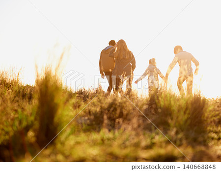 Family, nature and walk at sunset, bonding and exercise for parents and children. Lens flare, autumn and grass for hike on holiday in English countryside, mother and father for outdoor activity Family, nature and walk at sunset, bonding and exercise for parents and children. Lens flare, autumn and grass for hike on holiday in English countryside, mother and father for outdoor activity 140668848