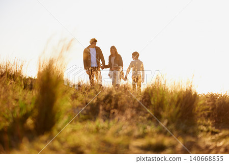 Family, grass and walk at sunset, nature and bonding with exercise for parents and children. Lens flare, autumn and hike on holiday in English countryside, mother and father for outdoor activity Family, grass and walk at sunset, nature and bonding with exercise for parents and children. Lens flare, autumn and hike on holiday in English countryside, mother and father for outdoor activity 140668855
