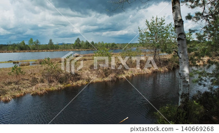 Bog lake landscape with forest under sky with clouds Bog lake landscape with forest under sky with clouds 140669268