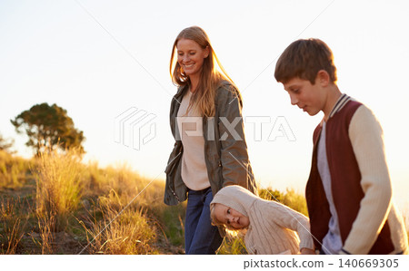 Happy, mother and children on nature walk, family or fun for health in morning. Exercise and child in countryside with kids holding hands, smile in field on vacation or holiday with people together Happy, mother and children on nature walk, family or fun for health in morning. Exercise and child in countryside with kids holding hands, smile in field on vacation or holiday with people together 140669305