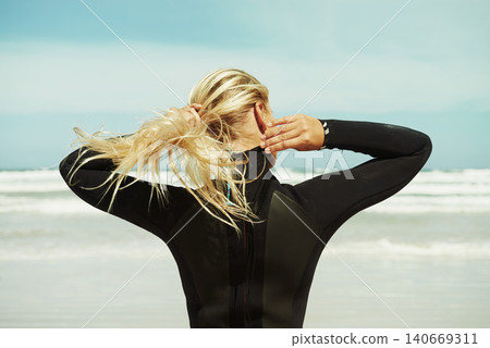 Girl, prepare and swimsuit for swimming in beach, blue sky and freedom in nature for adventure. Athlete, outdoor and training for sports, sunshine and sea with waves in water, fit and standing 140669311