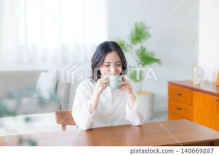 Young woman drinking coffee in the living room 140669887