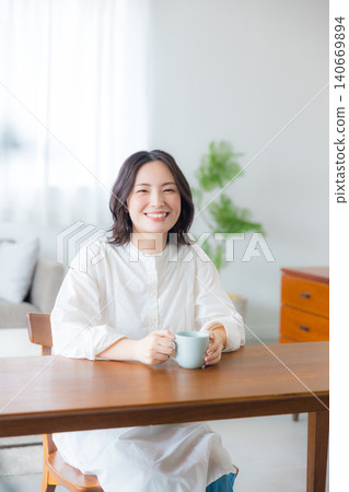 Young woman drinking coffee in the living room 140669894