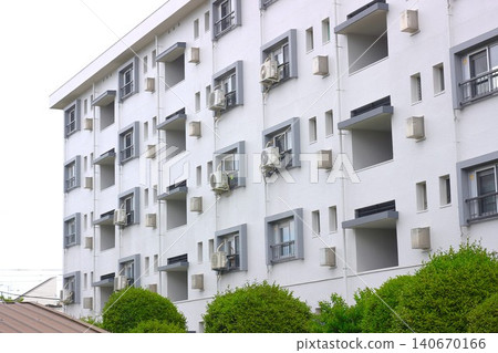 A retro Showa-era apartment building characterized by its regularly spaced windows and balconies. 140670166
