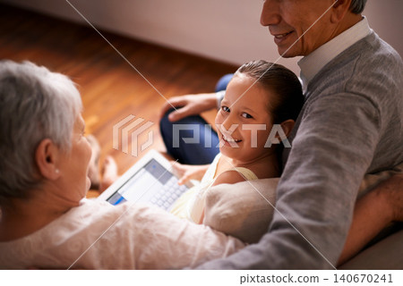 Child, grandparents and tablet on couch in home or online game or communication, teaching or connection. Elderly couple, retirement and girl or internet learning in apartment, development or bonding Child, grandparents and tablet on couch in home or online game or communication, teaching or connection. Elderly couple, retirement and girl or internet learning in apartment, development or bonding 140670241