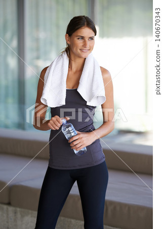 Fitness, thinking and happy woman with water, towel and commitment to body, yoga and workout. Gym, bottle and girl with exercise, training and pilates for health, wellness and drinking with smile 140670343