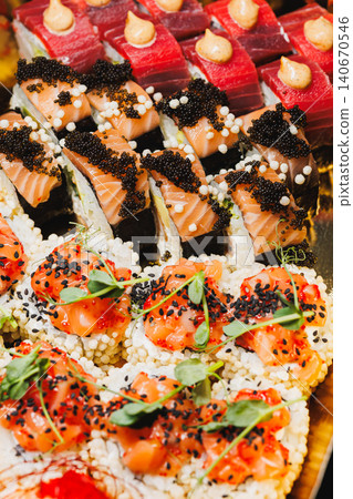 Sushi platter with assorted types of sushi served on a large tray at a gathering in a restaurant 140670546