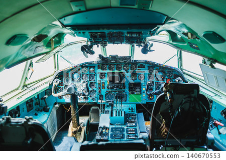 Pilot cockpit of a large aircraft showing control panels and instruments during daylight Pilot cockpit of a large aircraft showing control panels and instruments during daylight 140670553