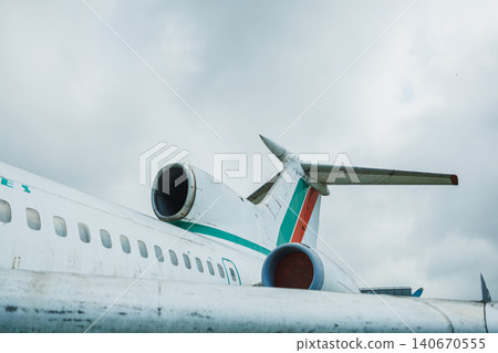 Large passenger airplane on a tarmac at an airport with a cloudy sky in the background near the terminal building Large passenger airplane on a tarmac at an airport with a cloudy sky in the background near the terminal building 140670555