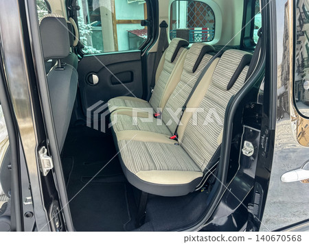 Interior view shows the back seats of a vehicle parked in a residential area during the day with natural light coming in through the windows Interior view shows the back seats of a vehicle parked in a residential area during the day with natural light coming in through the windows 140670568