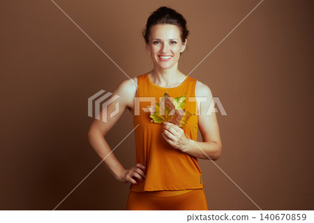 Cheerful Woman with Autumn Leaves in Activewear Cheerful Woman with Autumn Leaves in Activewear 140670859