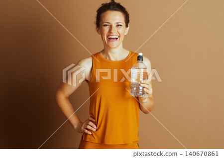 Cheerful Woman Poses with Water Bottle Cheerful Woman Poses with Water Bottle 140670861
