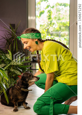 Woman Interacting With Small Dog Near Houseplants Woman Interacting With Small Dog Near Houseplants 140671292
