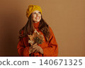 Joyful Young Woman Gazing Upwards with Fall Leaves 140671325