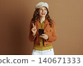 Inspired Woman Pointing Up with Smartphone 140671333