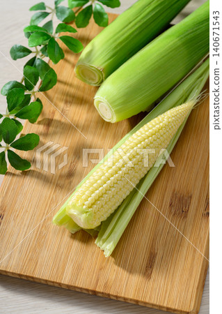 Fresh baby corn and a wooden cutting board Fresh baby corn and a wooden cutting board 140671543
