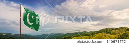 The national flag of Pakistan fluttering in the wind on a flagpole with a panoramic background of green hills and a cloudy blue sky The national flag of Pakistan fluttering in the wind on a flagpole with a panoramic background of green hills and a cloudy blue sky 140671752