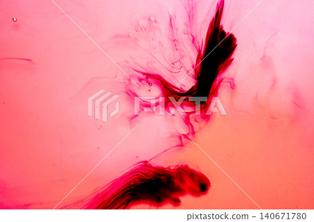 Abstract macro photography of red and black ink diffusing in liquid, creating beautiful organic swirls, smoky shapes and a fluid textured background 140671780