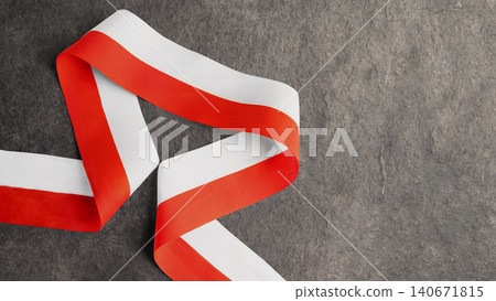 A satin ribbon in the colors of the Indonesian national flag (red and white) beautifully curved on a dark gray slate textured background with copy space.. Hari Kemerdekaan Dirgahayu Indonesia A satin ribbon in the colors of the Indonesian national flag (red and white) beautifully curved on a dark gray slate textured background with copy space.. Hari Kemerdekaan Dirgahayu Indonesia 140671815