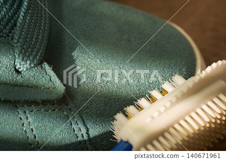 Bristle brush demonstration. Device effectively cleans sneaker seams from dirt. Closeup of bristle tool scrubbing textured suede material Bristle brush demonstration. Device effectively cleans sneaker seams from dirt. Closeup of bristle tool scrubbing textured suede material 140671961