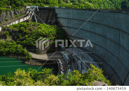 The beautiful arch-type concrete dam "Mizudono Dam" surrounded by fresh greenery. The beautiful arch-type concrete dam "Mizudono Dam" surrounded by fresh greenery. 140673459