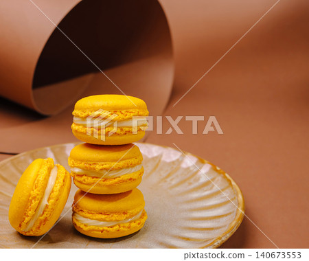 Yellow lemon macarons stacked on a plate 140673553
