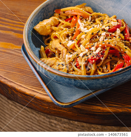 Asian udon noodles with chicken, vegetables, and sesame seeds Asian udon noodles with chicken, vegetables, and sesame seeds 140673561