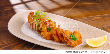 Fried breaded shrimp with sauce and lemon on wooden table 140673570