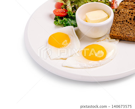 Fried eggs with fresh salad and toast on plate 140673575