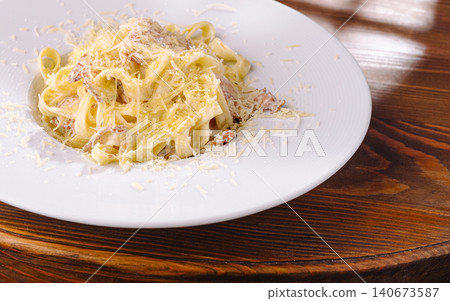 Fettuccine carbonara with grated parmesan cheese on white plate Fettuccine carbonara with grated parmesan cheese on white plate 140673587