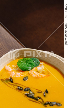 Pumpkin cream soup with shrimp and pumpkin seeds Pumpkin cream soup with shrimp and pumpkin seeds 140673627