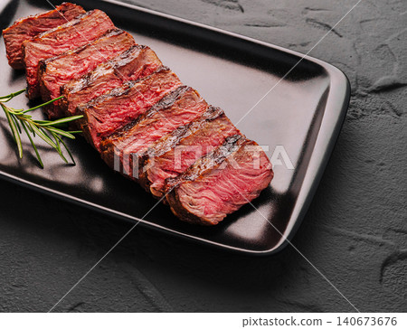 Grilled sirloin steak slices with rosemary on plate Grilled sirloin steak slices with rosemary on plate 140673676
