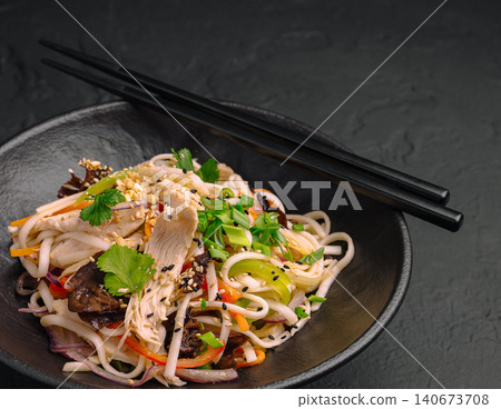 Chicken noodle salad with fresh vegetables and chopsticks Chicken noodle salad with fresh vegetables and chopsticks 140673708