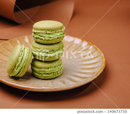 Green macarons stacked on plate with one beside Green macarons stacked on plate with one beside 140673730