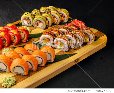 Sushi rolls set on wooden board with sauces 140673809